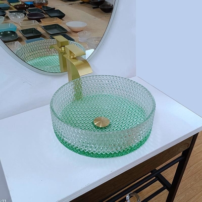 ダイヤモンドの形のクリスタル グラスの容器はテーブルの上の洗面器の緑の底を沈める