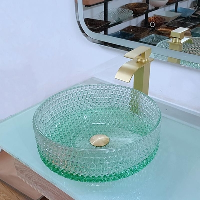 ダイヤモンドの形のクリスタル グラスの容器はテーブルの上の洗面器の緑の底を沈める