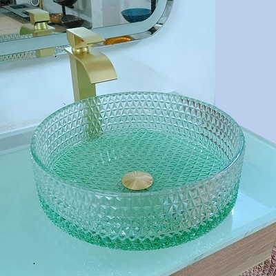 ダイヤモンドの形のクリスタル グラスの容器はテーブルの上の洗面器の緑の底を沈める